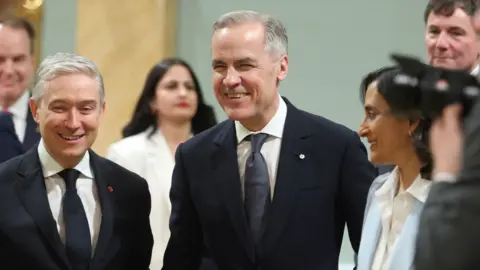 Canada's Prime Minister Mark Carney leaves a group photo after a swearing-in ceremony.