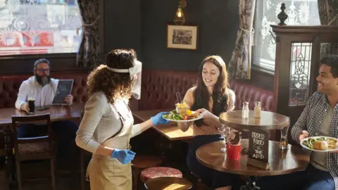 Getty Images Barmaid serving food in a pub