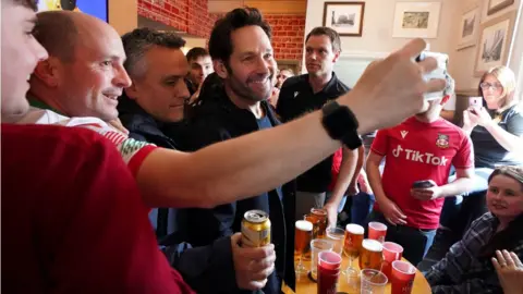 PA Media Hollywood actor Paul Rudd with Wrexham fans in the Turf pub