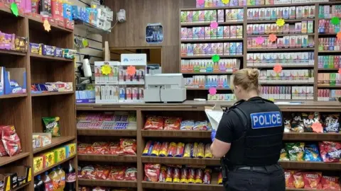 Leicestershire Police A police officer with a clipboard in a convenience store
