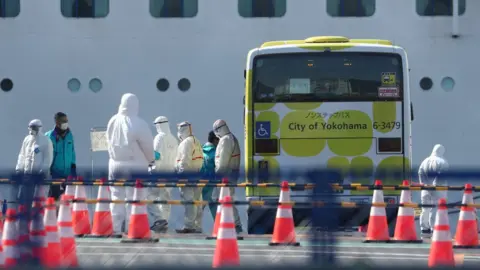 Reuters Workers in protective gear are seen near the cruise ship Diamond Princess at Daikoku Pier Cruise Terminal in Yokohama, south of Tokyo, Japan February 19, 2020.