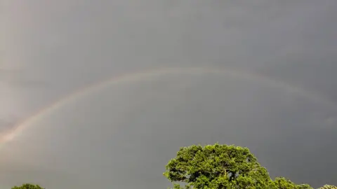 Megan Kay Searching for a pot of gold: Sixteen year old Megan Kay captured this rainbow amid stormy skies in Rhoslan, near Criccieth