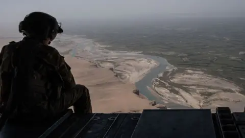 Getty Images A US Army helicopter flies over Camp Shorab in Helmand Province, Afghanistan.