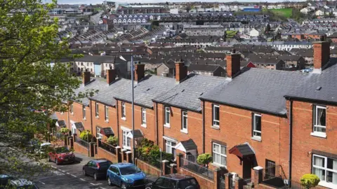 Getty Images Houses on a street with parked cars