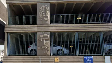 A Google Streetview image of the side of the car park showing two of the sculptures