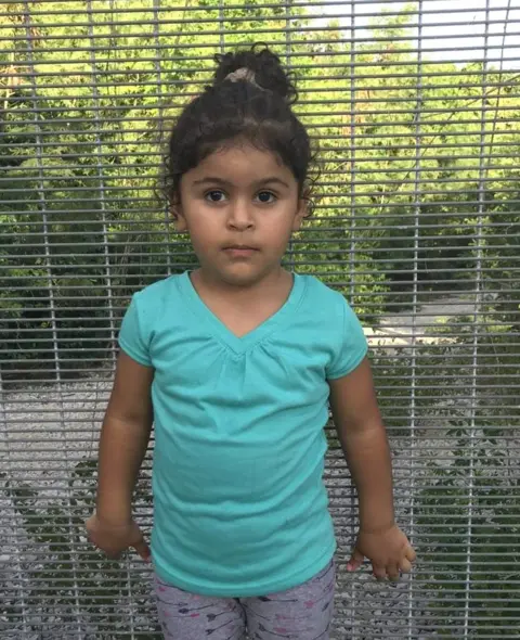 World Vision Australia Three year old Melanie stands in front of a fence in the island of Nauru