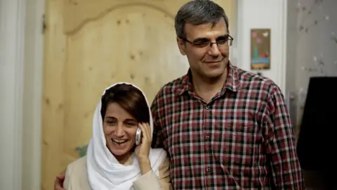 AFP/Getty Nasrin Sotoudeh (L) speaks on the phone next to her husband Reza Khandan in 2013