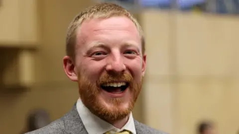 LDRS A close-up headshot of Colin Ferguson, leader of Newcastle Liberal Democrats. He is wearing a grey suit jacket and white shirt.