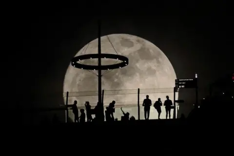 Suhaimi Abdullah/Getty Images The moon rises behind the Marina Bay Sands in Singapore