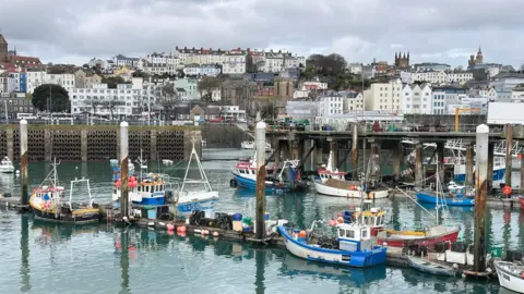 Guernsey fishing boats at Fish Quay St Peter Port on a cloudy day.