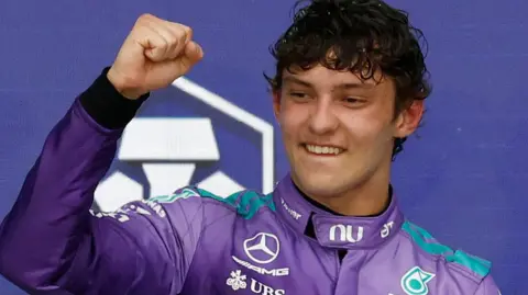 Kimi Antonelli clenches his fist in celebration on the podium after winning the Miami Grand Prix
