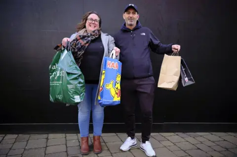 Julie Watson and Andrew Durrant holding their bags