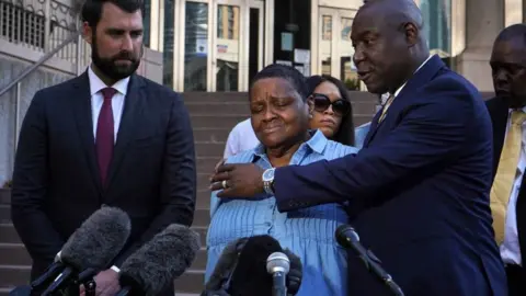 AFP via Getty Images Attorney Ben Crump embraces Astroworld Festival victim, Gertrude Daughtery