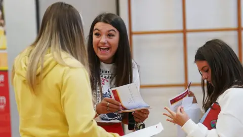 Brian Lawless/PA Atlanta Watson (centre) reacts after opening her A-level results at Lagan College, Belfast