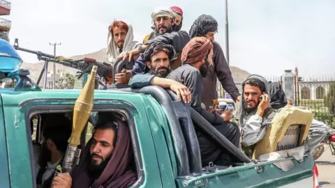 EPA Taliban fighters are seen on the back of a vehicle in Kabul, Afghanistan, 16 August 2021