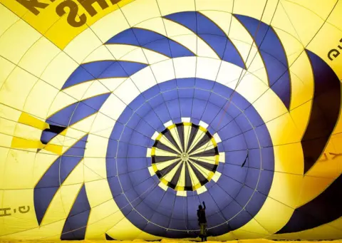 Charlotte Graham/REX/Shutterstock Linda Cossland-Clarke, Pilot of 3 Years Flying GHAZD, and a member of Women in Ballooning, checks the balloon fabric.