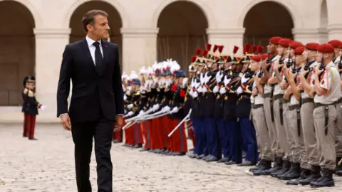 EPA French President Emmanuel Macron reviews troops during a national tribute to late French Army General Jean-Louis Georgelin, former Chief of Staff of the Armed Forces, former Grand Chancellor of the Legion of Honour, in charge of Notre-Dame de Paris Cathedral reconstruction, in the courtyard of the Hotel National des Invalides in Paris, France, 25 August 2023.