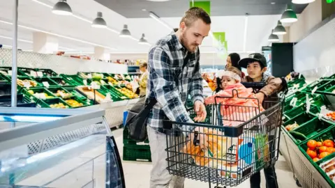 Getty Images Man in supermarket with two kids