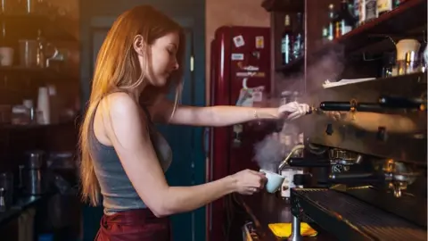 Getty Images Woman working in a coffee shop