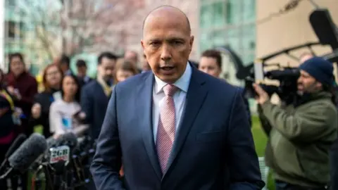 AFP/Getty Images Peter Dutton stands in front of a media pack after his failed challenge on Tuesday