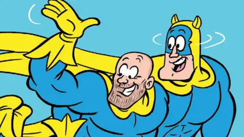 A cartoon image of Bananaman holding onto Mike Tindall as they fly through the air. They are wearing matching blue and yellow costumes. 