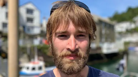 Young man with a beard and moustache and sunglasses on his head