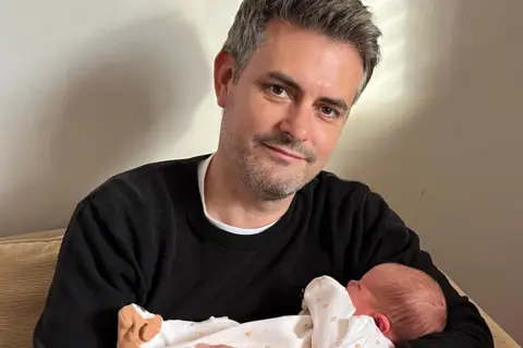 Jon Pearce Jon Pearce holding his daughter in his arms