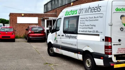Doctors on Wheels A white Mercedes van with Doctors on Wheels signage parked in an office car park in front of some red cars