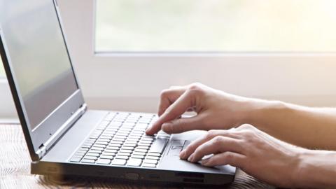 Person using a keyboard on a laptop
