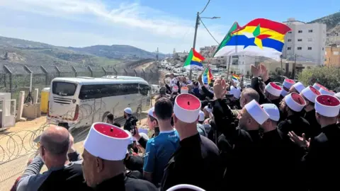 Reuters Druze people in Majdal Shams welcome buses carrying a Druze delegation from Syria