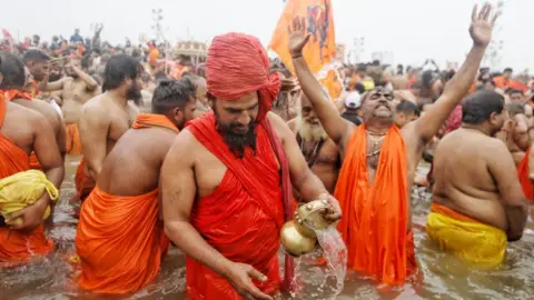 Ankit Srinivas Holy men in saffron robes seen taking a dip in the river