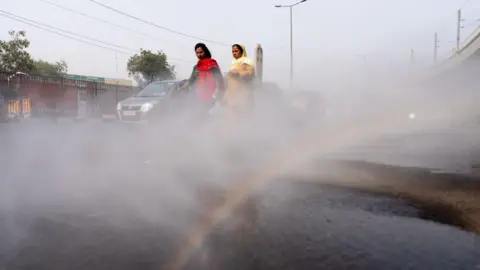 Getty Images Water sprayed onto road in Delhi