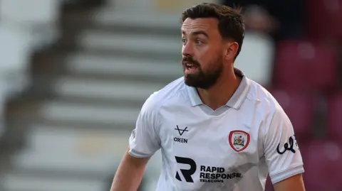 Eoghan O'Connell in action for Barnsley wearing a white away jersey
