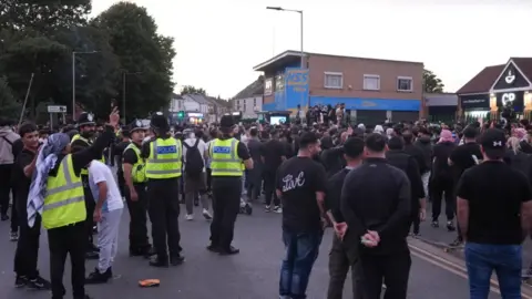 PA Media People and police gathered on Lincoln Road 