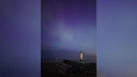 The Northern Lights seen from New Brighton in Wirral, with a view of the lighthouse