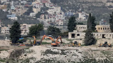 Escavadeiras israelenses da EPA nivelam terreno no assentamento israelense evacuado de Sanur, perto de Jenin, na Cisjordânia ocupada (23 de dezembro de 2025)