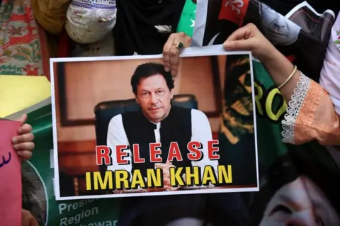 A supporter of Pakistan Tehreek-e-Insaf (PTI) party holds a sign with a portrait of Pakistan"s jailed former Prime Minister and PTI founder Imran Khan during a protest rally demanding his and his wife release, in Peshawar, Pakistan, 26 April 2024.