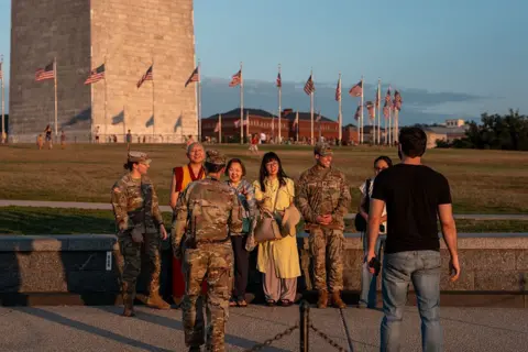 National Guard troops appear in Washington DC as mayor rejects 'authoritarian push' Getty Images Troops were seen posing with tourists on the National Mall near the Washington Monument