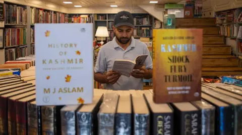 A man looks at a book in a bookstore in Indian-administered Kashmir