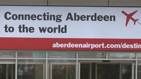 PA Media 'Connecting Aberdeen to the world' sign at Aberdeen International Airport.