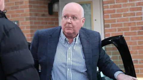 PA Media Peter Murrell climbing out of a car outside a modern home