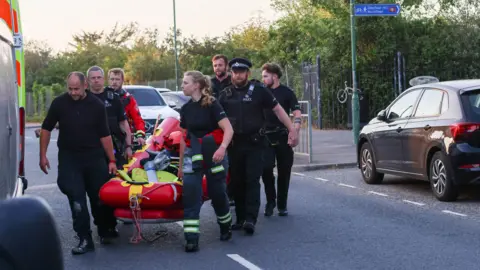 UKNIP A rescue crew including police carry a lifeboat 