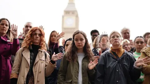 People take part in a vigil organised by Medical Aid for Palestinians at Parliament Square