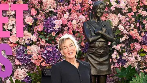 Getty Images Renée Zellweger poses in front of the Bridget Jones Scenes In The Square Statue at its unveiling at Leicester Square on November 17, 2025 in London, England. 
