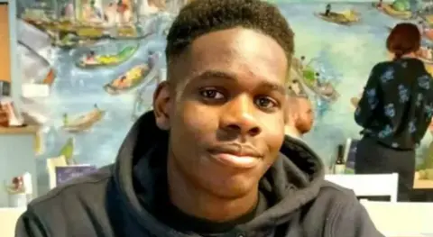 Family handout Young man with black hoodie and dark skin smiling softly at the camera