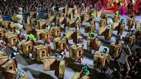 Getty Images Revellers of the Academicos do Salgueiro samba school perform as dancing books.