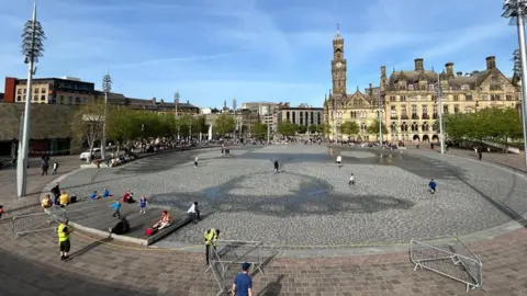 An empty water feature, a paved area in a city centre.
