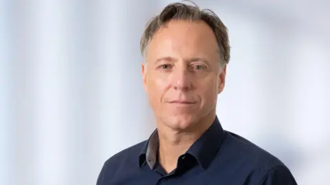 University Medical Center Gotingen Wolfram-Habertus Zimmaraman, Professor and Researchers at University Medical Center Gotingen wear Navy Blue Shirts and Jumper and appear directly on camera.