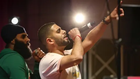 Premz Premz holding mic and rapping