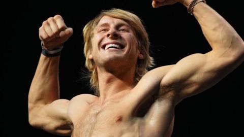 Paddy Pimblett grins with his long blonde hair at a weigh-in